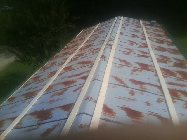 Rusted metal roof panels with new wood purlins before replacement — Storm Damage Roof Repair in East Stroudsburg by Roofing Brothers