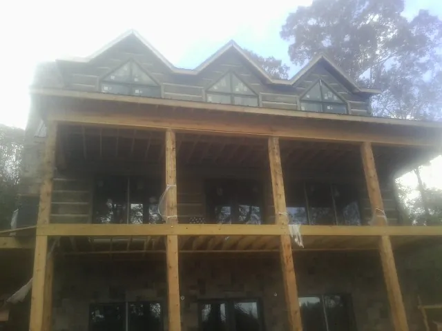 Dormers and porch framing on a large log home under construction — Roof Coating work by our crew in East Stroudsburg