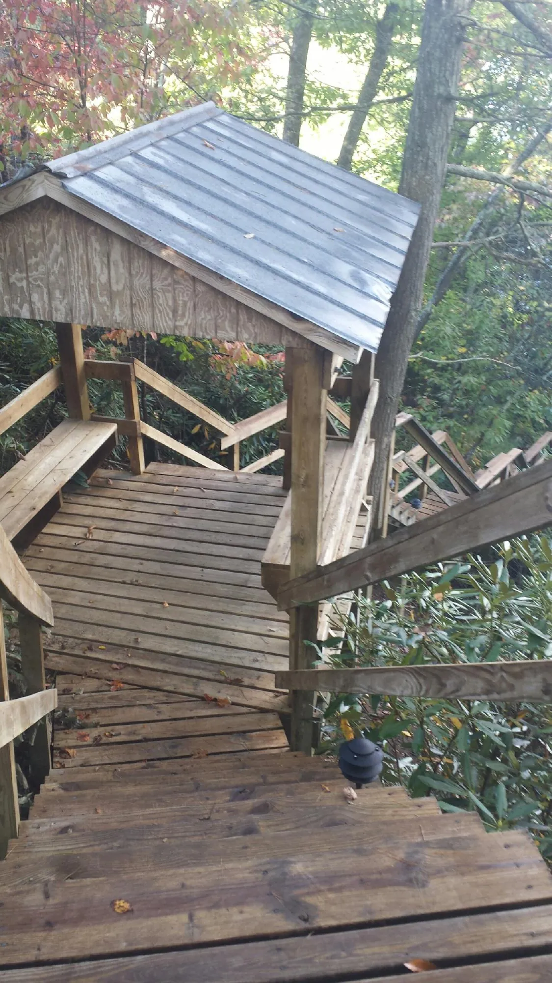 Metal roofed shelter over wooden steps on a wooded walkway — Skylight Repair & Installation work by our crew in East Stroudsburg